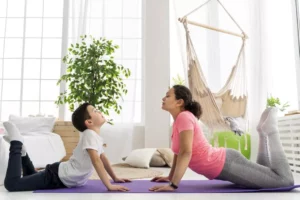 Mãe e filho trabalhando o desenvolvimento neuropsicomotor em uma aula de Yoga.