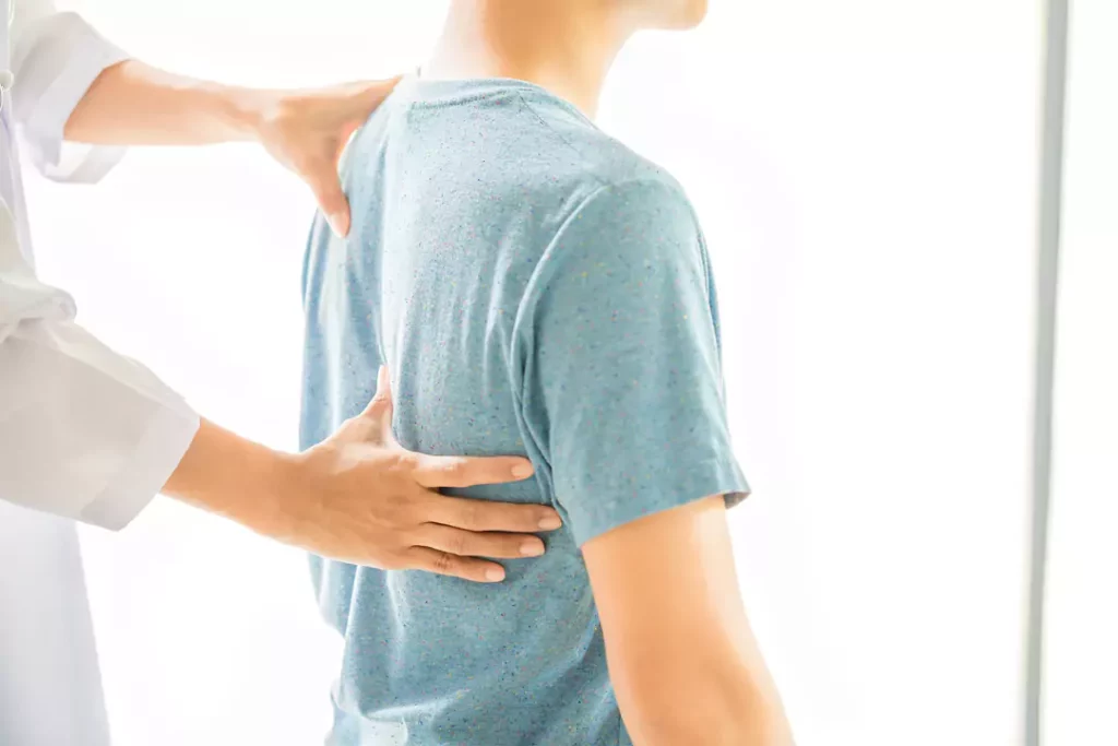 Homem passando com médica para avaliar sua Escoliose.